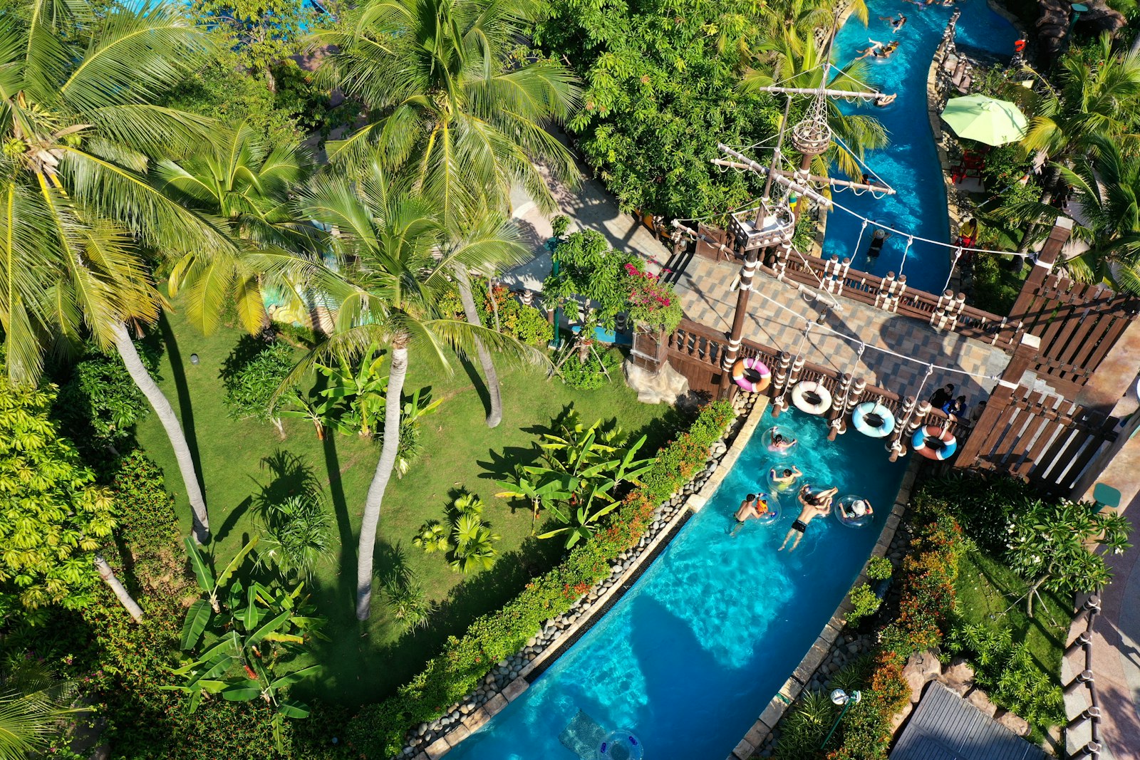 People floating in a lazy river at a tropical resort.