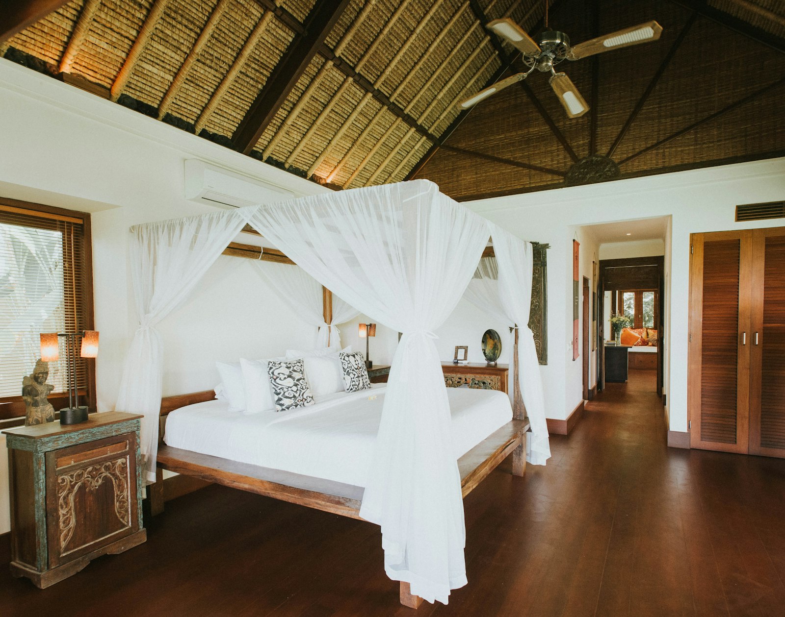 A bedroom with a bed and a ceiling fan